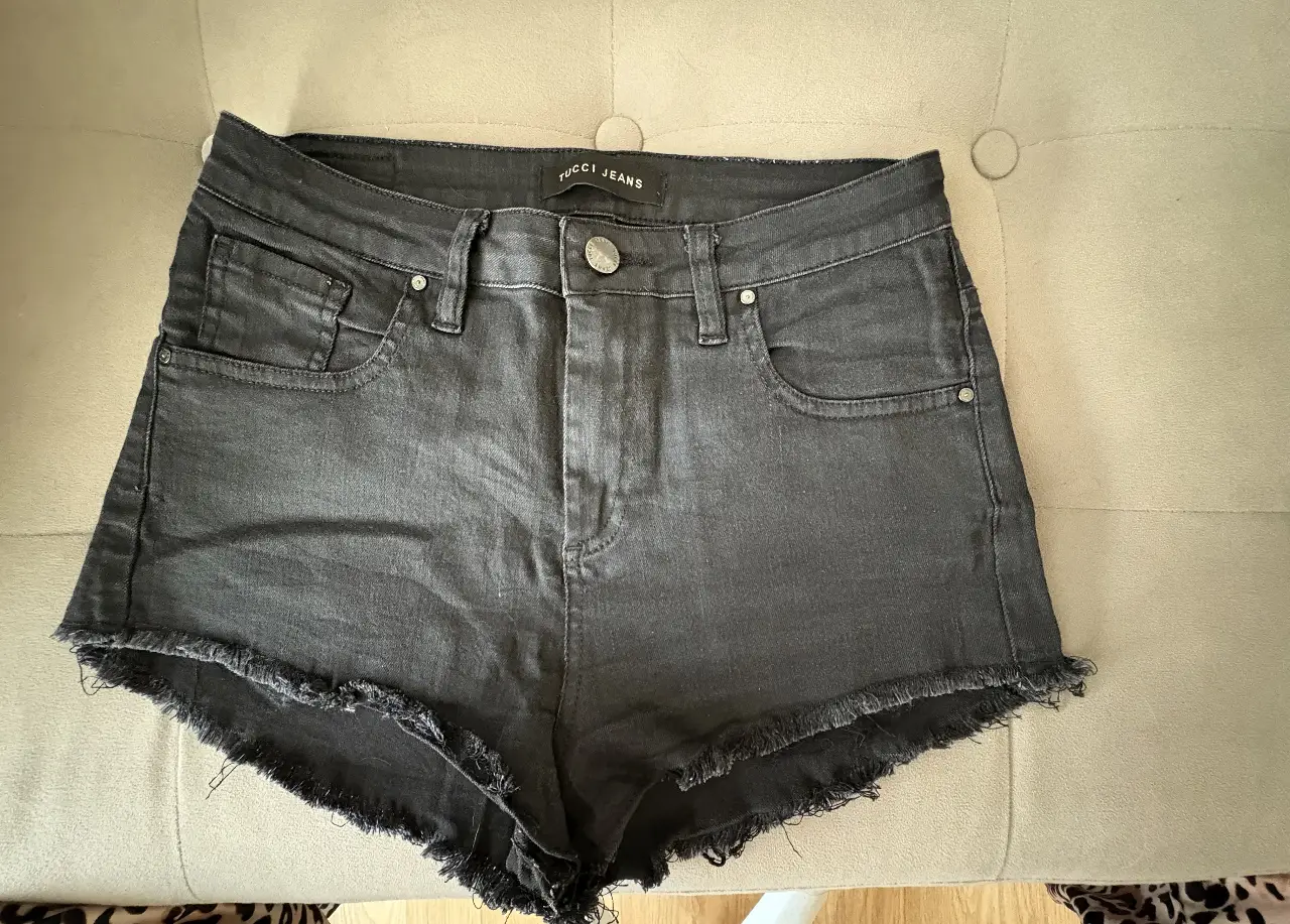 Short de jean Tucci  negro con flecos en el borde. Talle XS, ideal para un look casual y moderno.