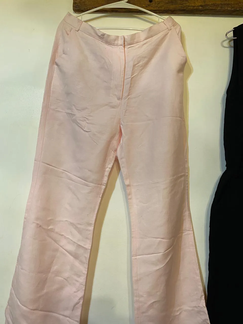 Pantalón rosa de vestir con pinzas delanteras y cierre.