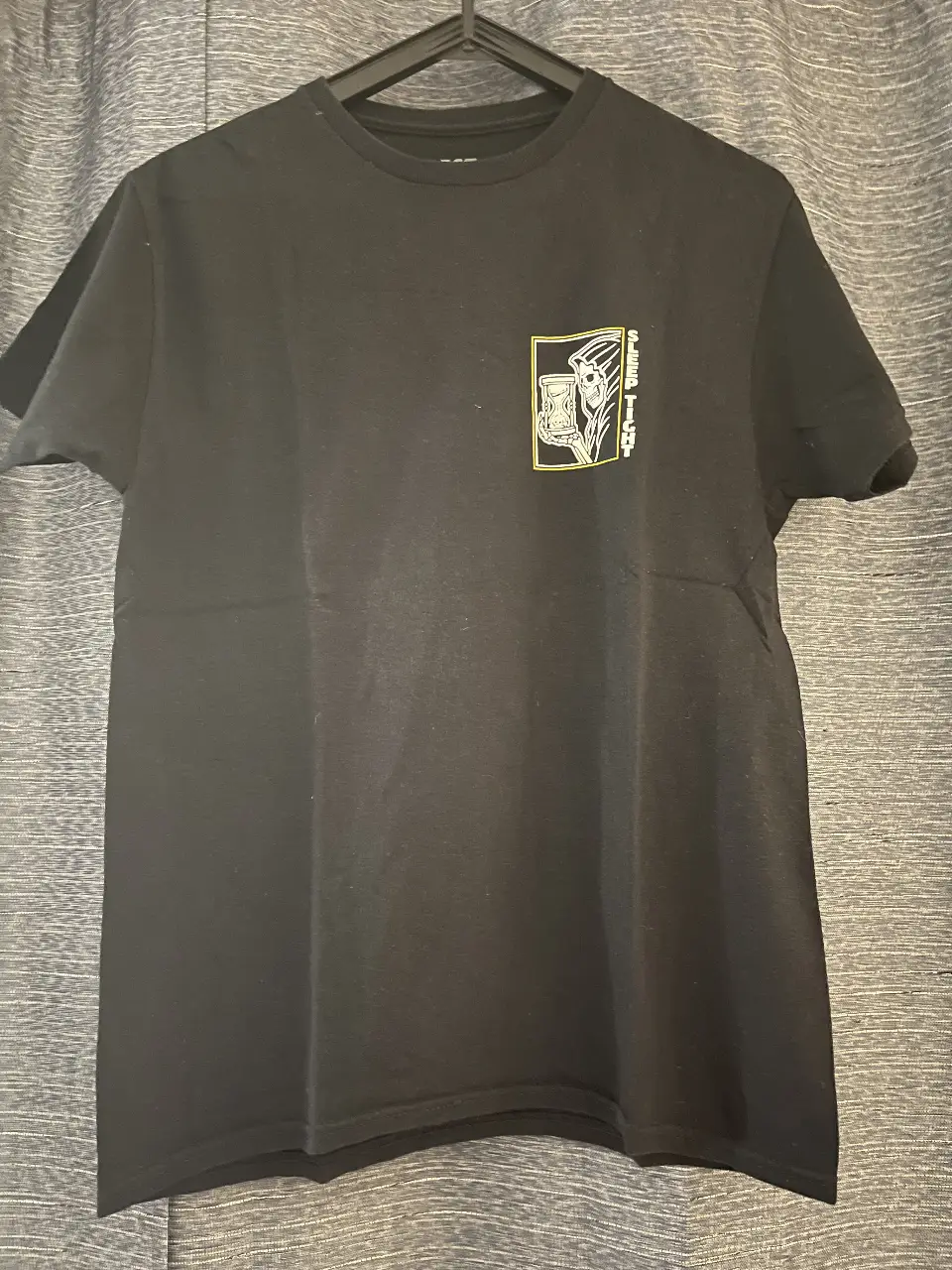 Remera negra de hombre con estampado en el frente y la espalda. Diseño con motivos de calavera y frase "Sleep Tight, Rest Easy". Ideal para un look casual y con onda.