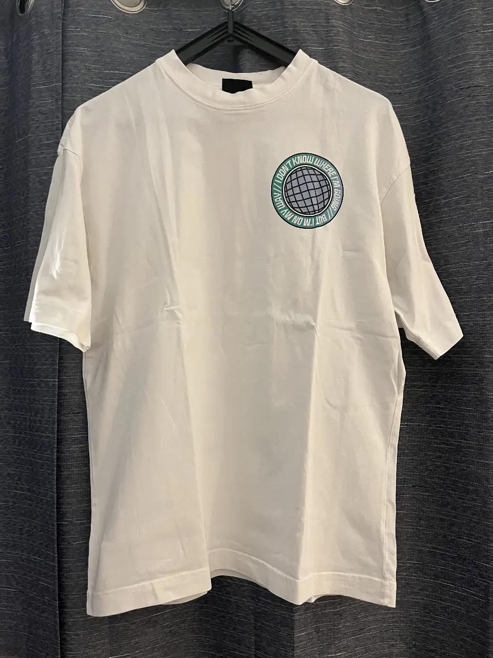 Remera blanca de hombre con estampado "Somewhere Everywhere" en la espalda y logo en el frente. Corte oversized, ideal para un look casual y cómodo.