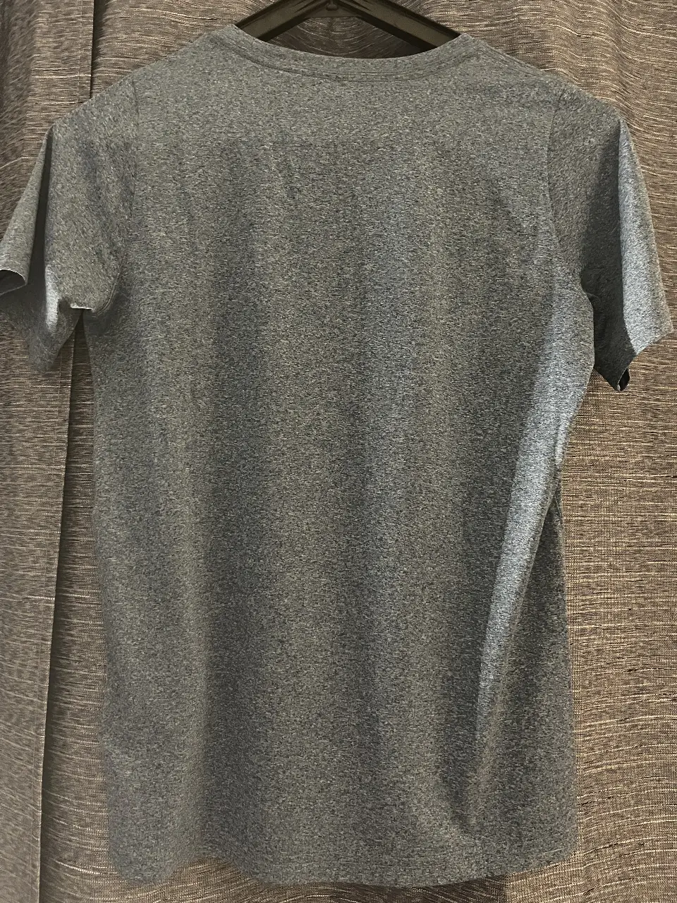 Remera deportiva de hombre, color gris con el logo de la marca en amarillo. Ideal para entrenar o usar en el día a día.