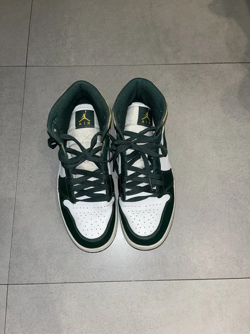 Zapatillas Air Jordan 1 Mid en color verde y blanco, con detalles en amarillo. Talle 10 US.