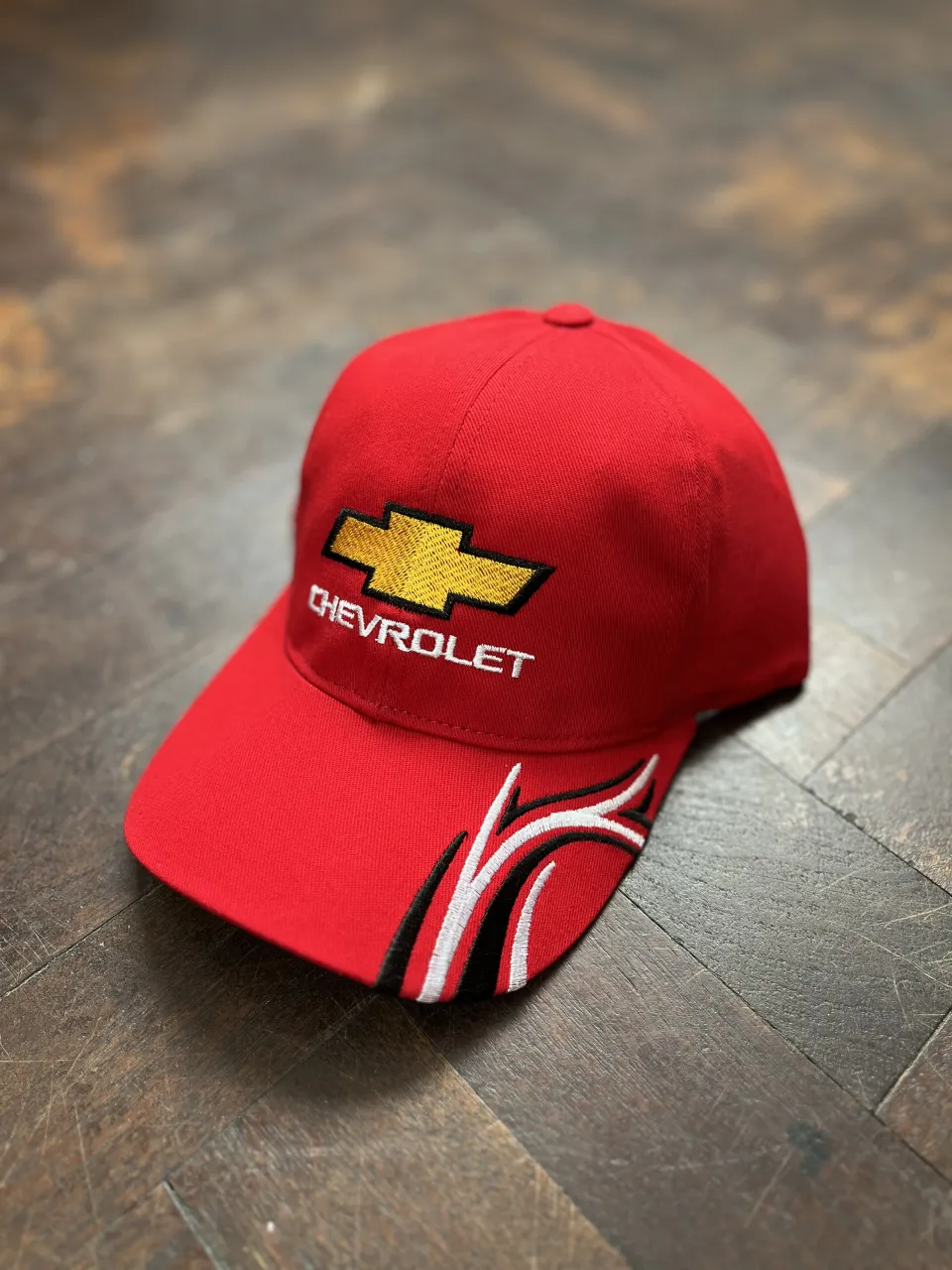 Gorra roja de Chevrolet con logo bordado y detalles de diseño en los laterales. 
