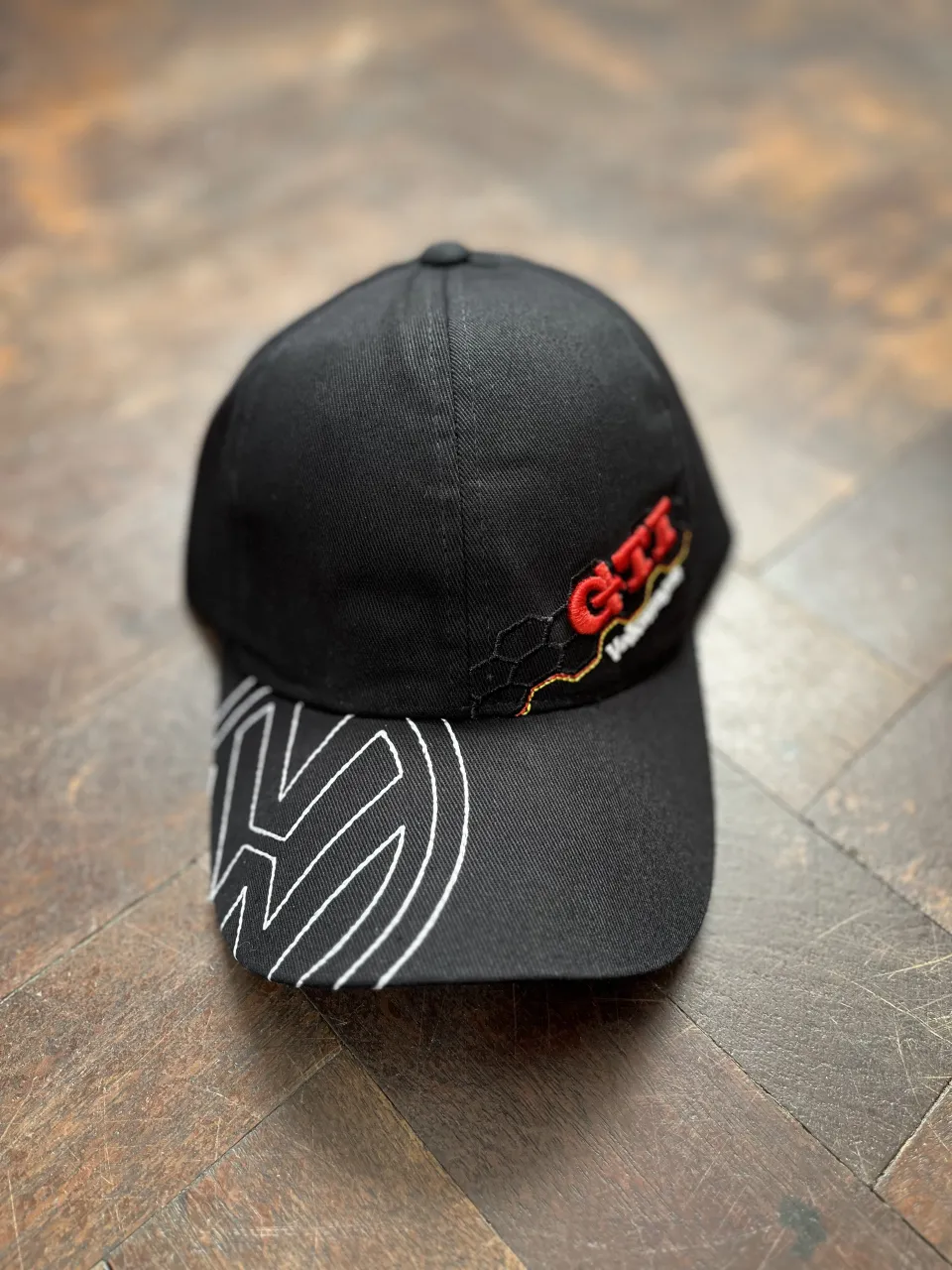 Gorra negra con logo GTI Volkswagen bordado en rojo y blanco. 