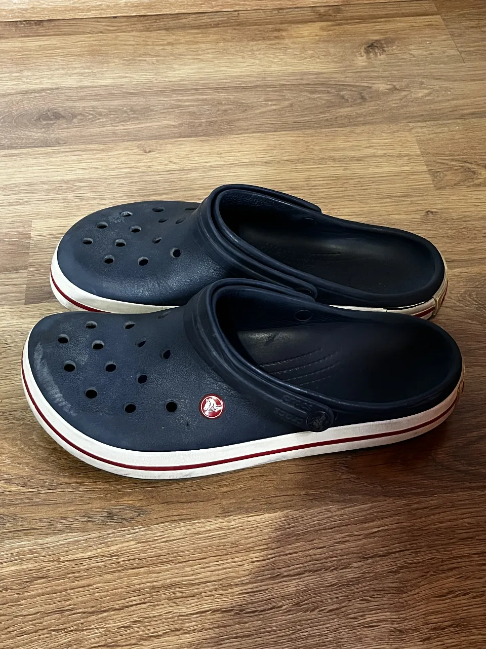¡Comodidad y estilo para tus pies! Estás crocs azul marino son perfectos para el día a día, ya sea para estar en casa, salir a la calle o para tus aventuras al aire libre. Su diseño clásico con suela blanca y detalles en rojo los hace súper versátiles. ¡Ideales para un look relajado y canchero!