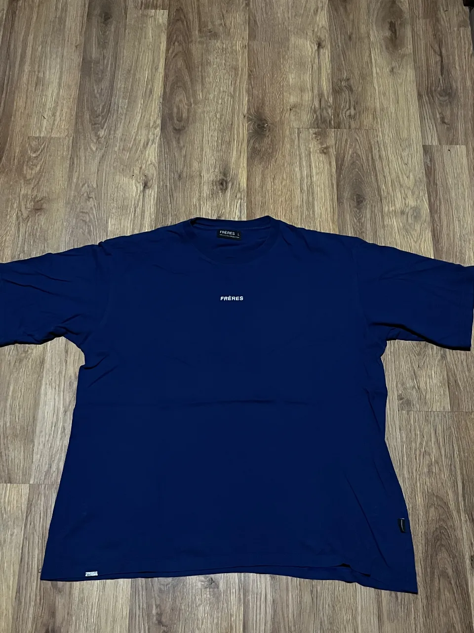 Remera azul marino lisa con logo pequeño de la marca FRERES en el frente. Ideal para un look casual y moderno.