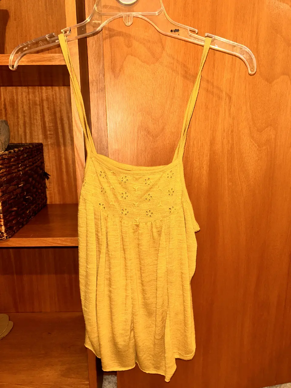 Top amarillo con breteles finos y detalles calados en la parte superior. Ideal para un look fresco y casual.