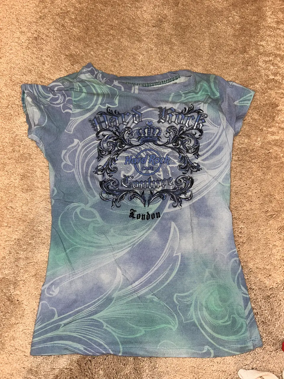 Remera Hard Rock Couture London, con estampado en la parte delantera y detalles en la espalda. Talle XS, ideal para un look casual y con estilo.