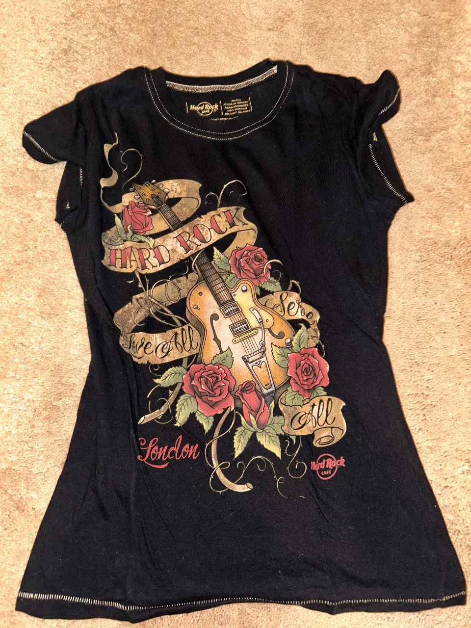 Remera negra de Hard Rock Cafe London, con estampado de guitarra, rosas y detalles en dorado. Talle Small, ideal para un look rocker casual.