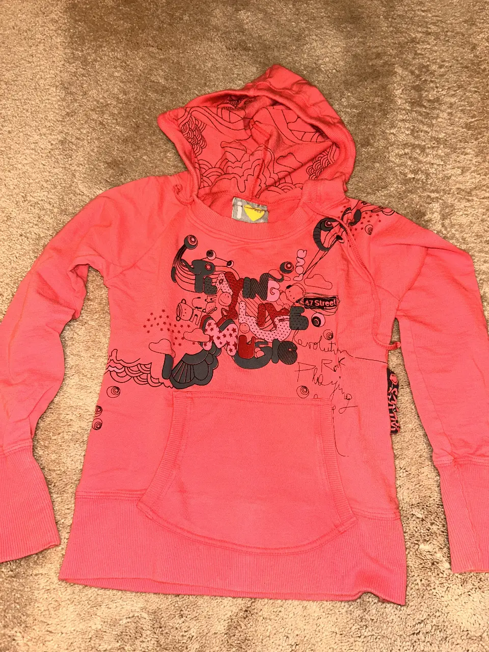 Buzo canguro rosa con capucha y estampado. Ideal para un look casual y cómodo.