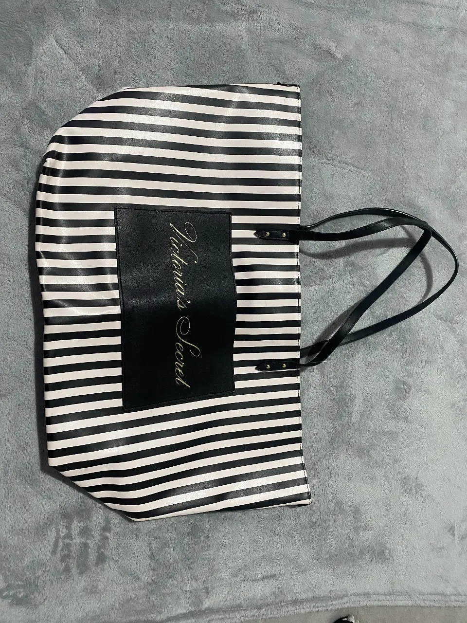 Bolso tote de Victoria's Secret a rayas blanco y negro. Ideal para playa o uso diario. Amplio y resistente, con bolsillo interno y manijas negras.