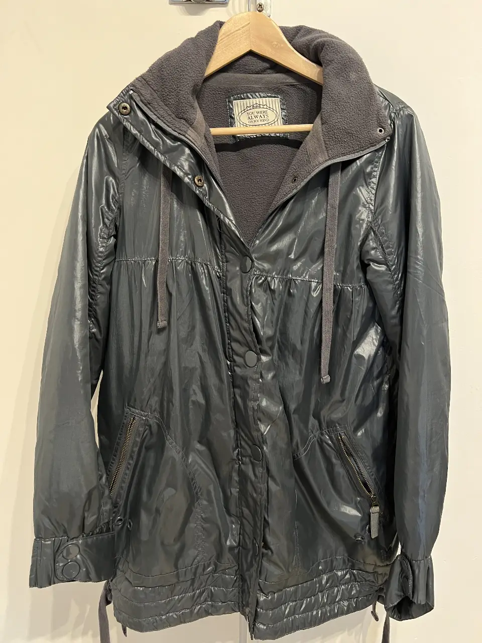 Campera gris oscura con capucha y cierre. Ideal para el invierno, con un diseño moderno y funcional. Cuenta con bolsillos con cierre y detalles en los puños.
