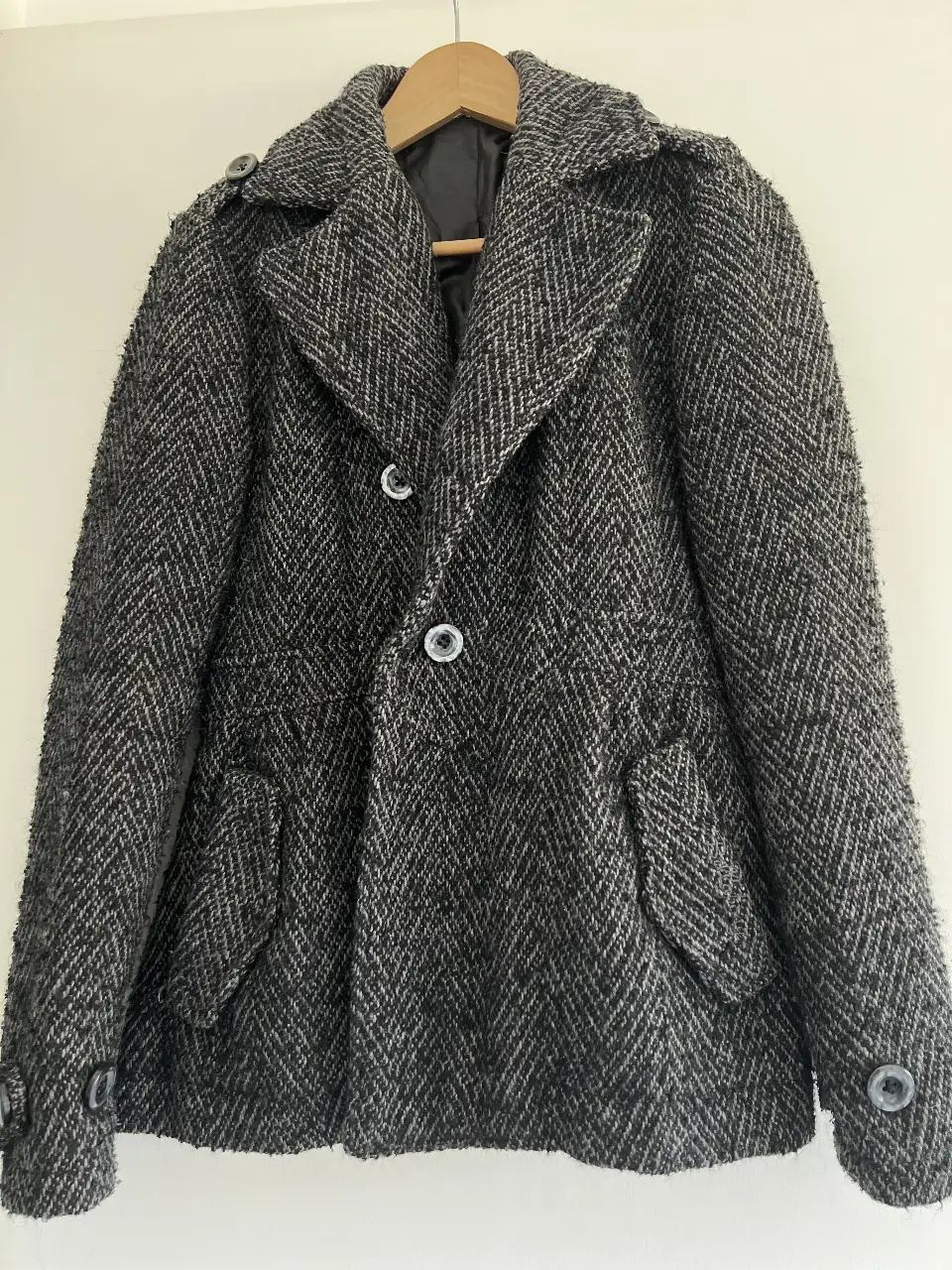 Campera bomber de hombre, con diseño de espiga en tonos grises y negros. Cuenta con dos bolsillos frontales y botones en los puños. Ideal para un look casual y moderno.