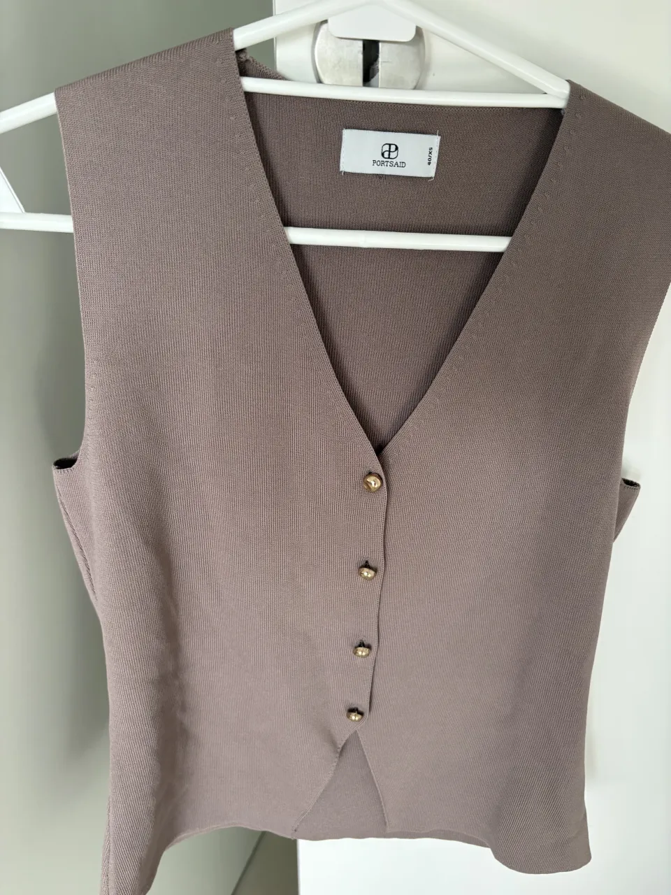 Chaleco de tejido color marrón, con escote en V y botones dorados al frente. Portsaid talle Xs (se estira, quizas va para un S tambien) No tiene uso.