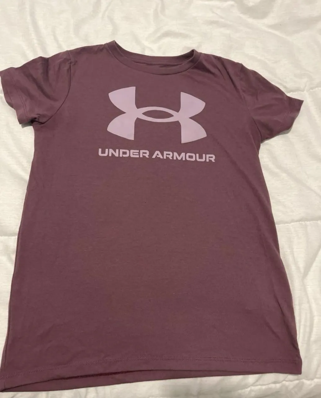 Remera de manga corta color morado con logo grande de Under Armour en el frente. Talle S. Poco uso
