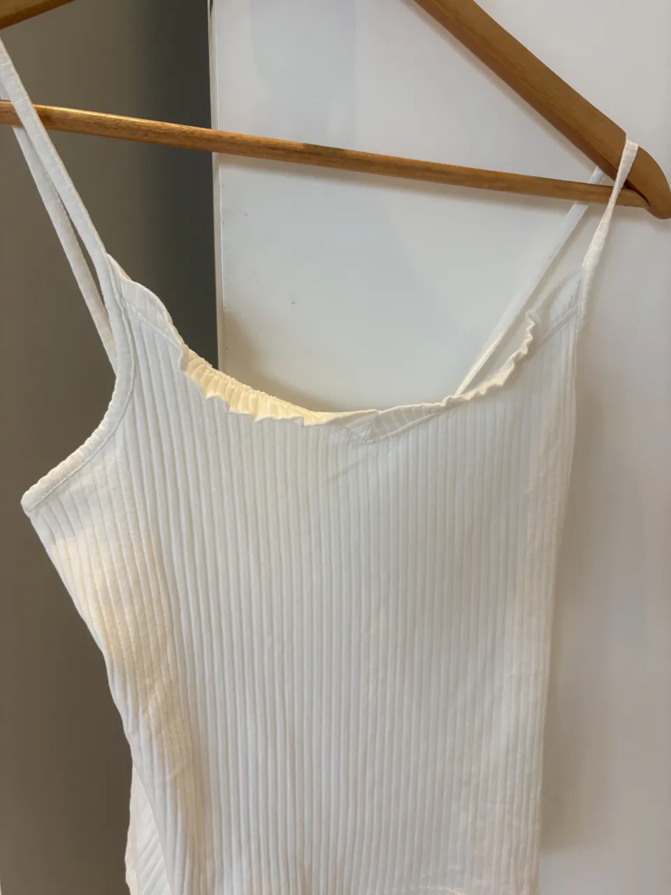 Musculosa blanca de morley con finos breteles y detalle de volados en el escote. Talle M de Ossira. Sin uso