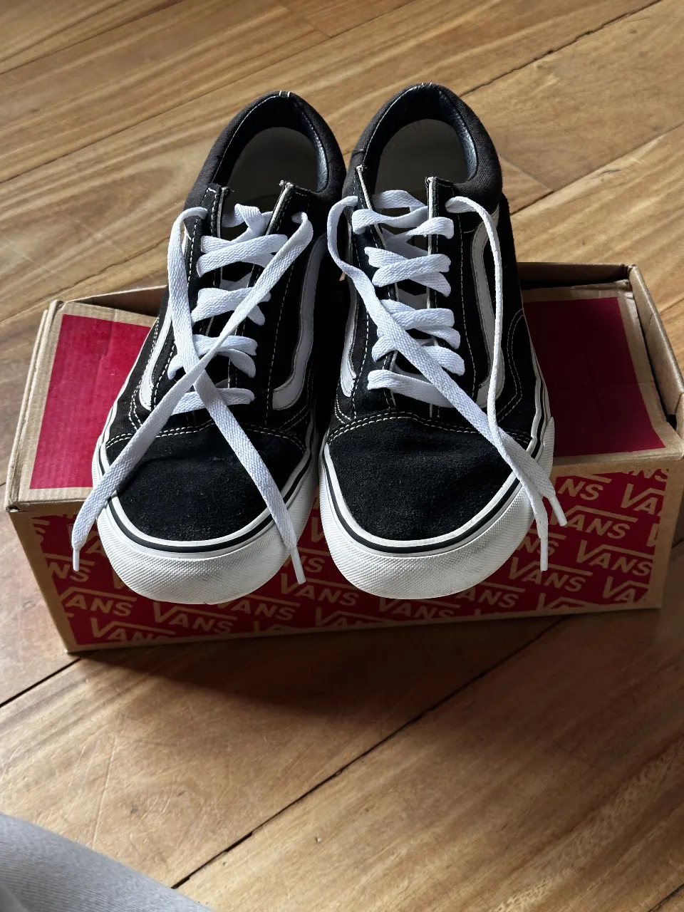 Zapatillas Vans Old Skool negras con detalles blancos. Tienen el clásico diseño de la marca, ideales para un look casual y urbano. Perfectas para combinar con cualquier outfit.