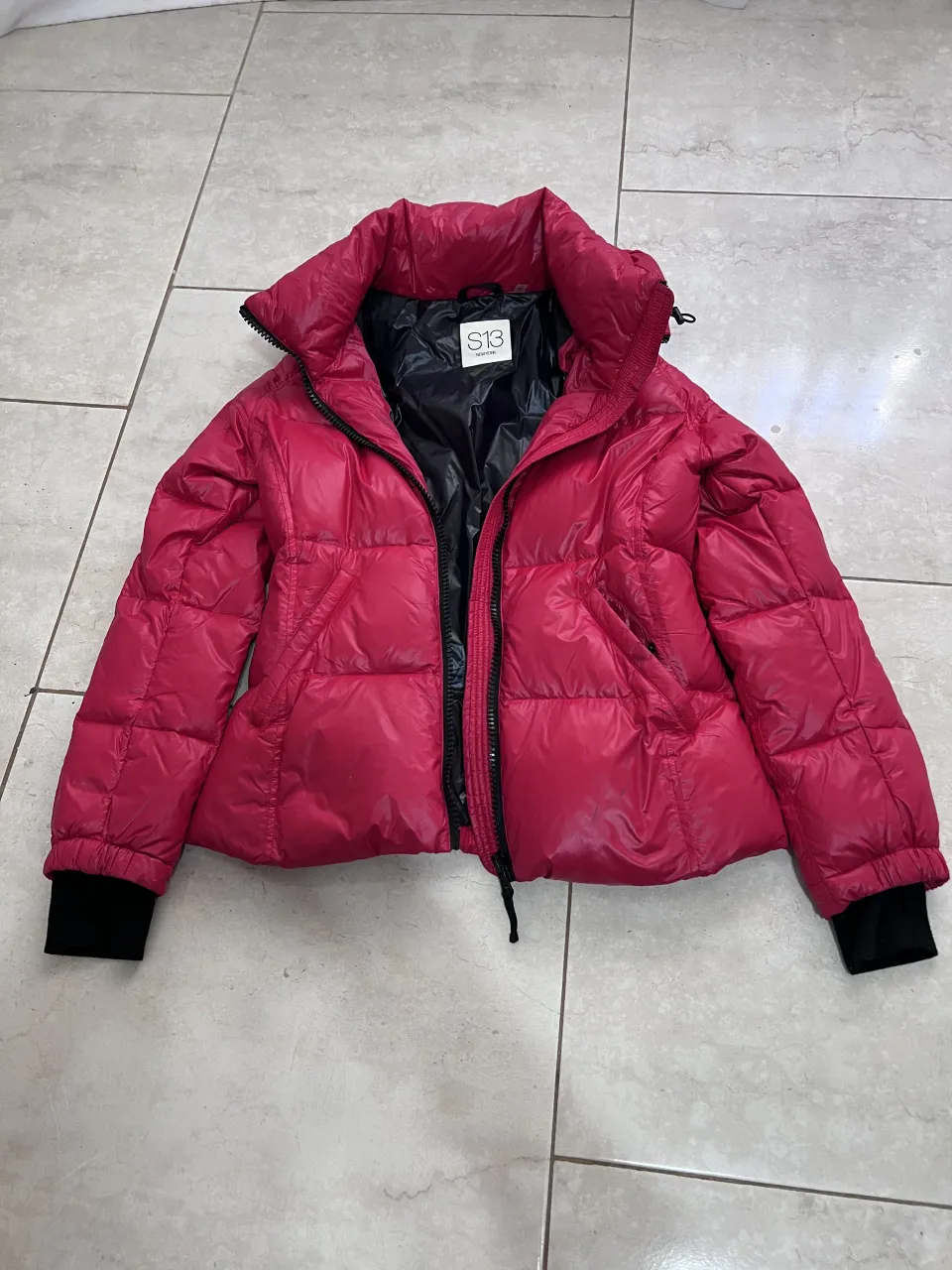 Campera acolchada corta con cuello alto y cierre al frente. Puños elastizados.