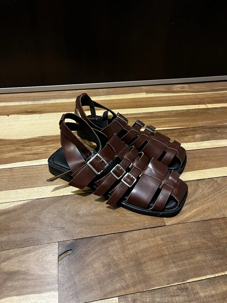 Sandalias de cuero marrón para hombre, con diseño de tiras y hebillas. Ideales para un look casual y cómodo en verano.