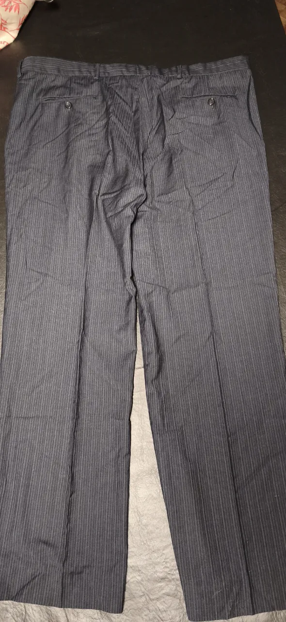 Pantalón de vestir a rayas verticales finas. Posee dos bolsillos traseros con botón. Largo 108 cm. cintura 53cm de ancho.