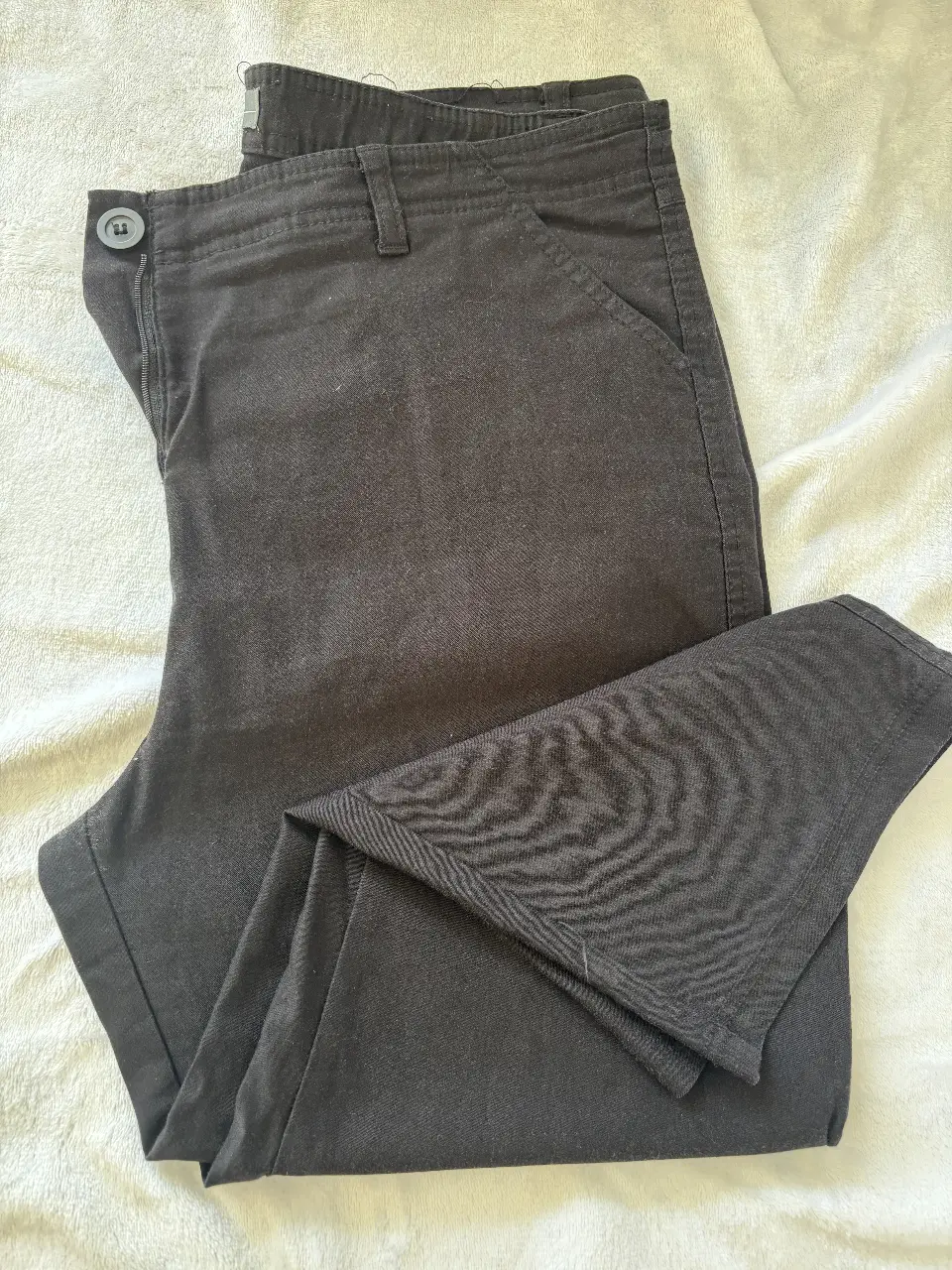 Pantalón capri negro de mujer, corte recto, con bolsillos delanteros y traseros. Ideal para un look casual y versátil.