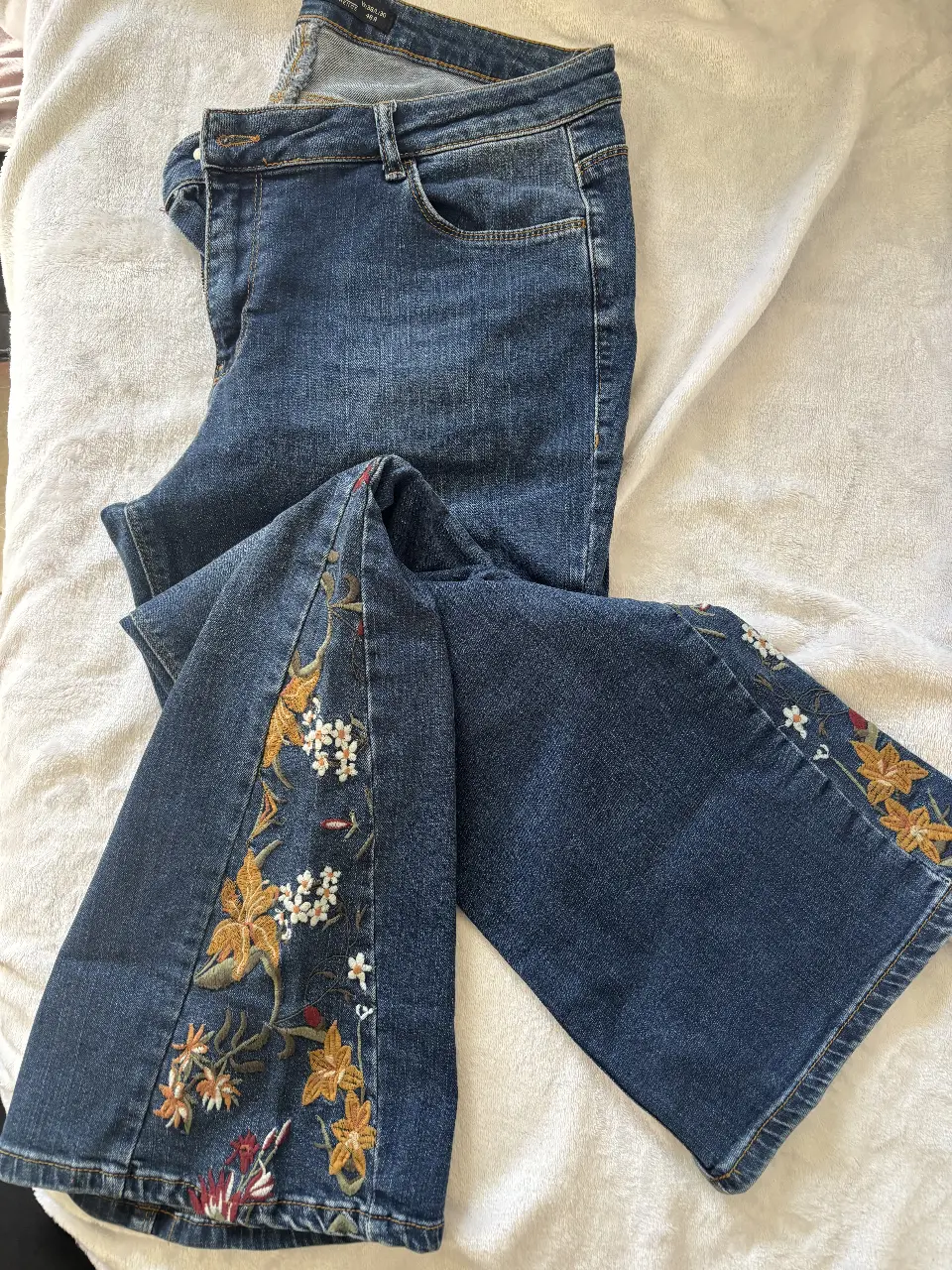 Jeans de mujer con bordado floral en los laterales de la bota. Tiro medio, corte recto y calce clásico. Un jean con onda para usar en cualquier ocasión. Es de Turquía. 