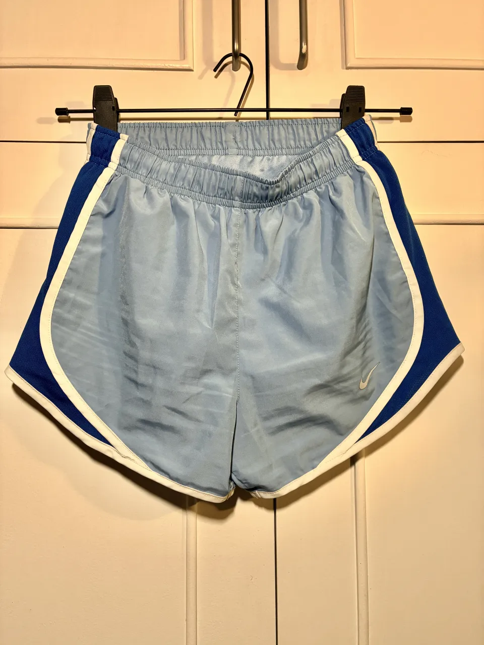 Shorts deportivos celestes con detalles en azul y blanco en los laterales. Cintura elastizada.