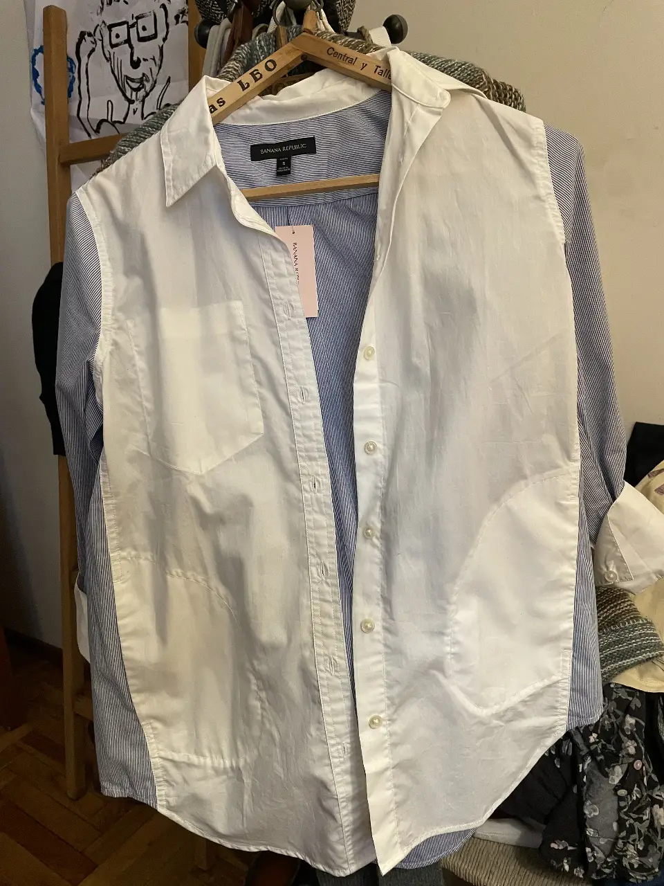 Camisa de mujer Banana Republic, talle S, con diseño a rayas en azul y blanco. La camisa tiene un diseño único con una capa blanca en la parte delantera. Ideal para un look casual y elegante.