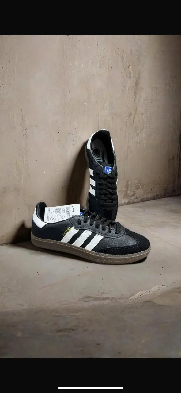 Zapatillas Adidas Samba negras con detalles blancos y suela de goma. Un clásico atemporal para un look casual y urbano.