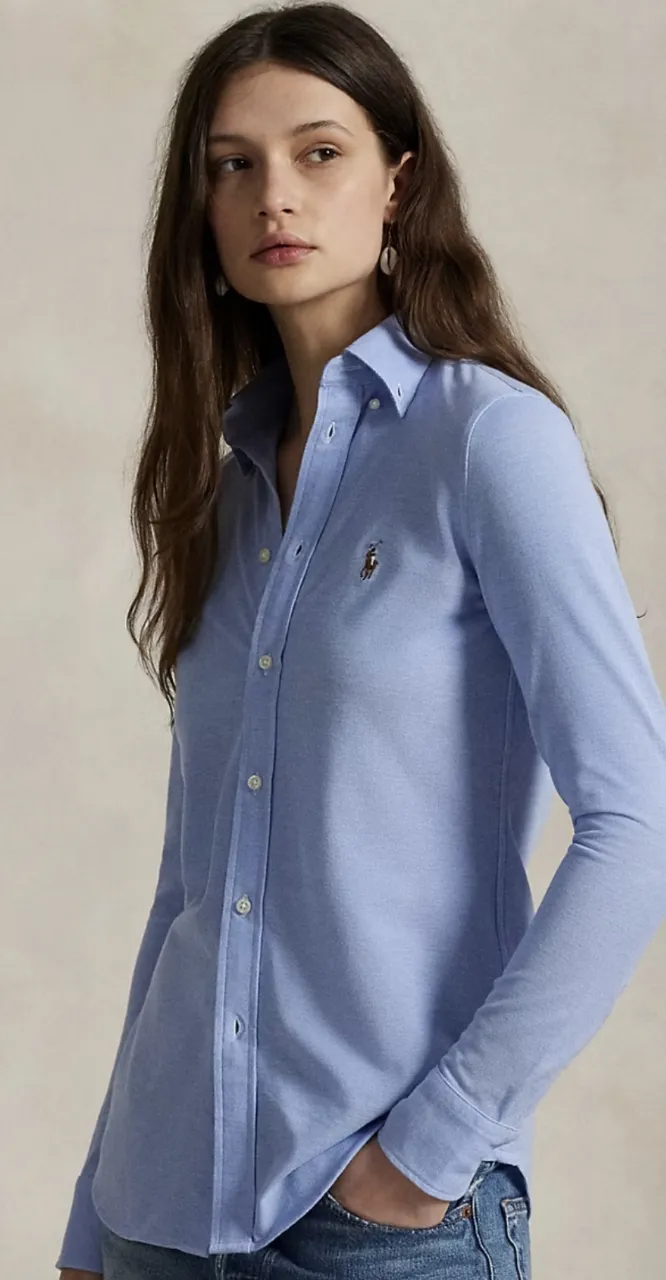 Camisa Oxford de manga larga para mujer, de la marca Polo Ralph Lauren. Confeccionada en tejido de punto suave y cómodo, ideal para un look casual y elegante. Presenta el icónico logo del jugador de polo bordado en el pecho.