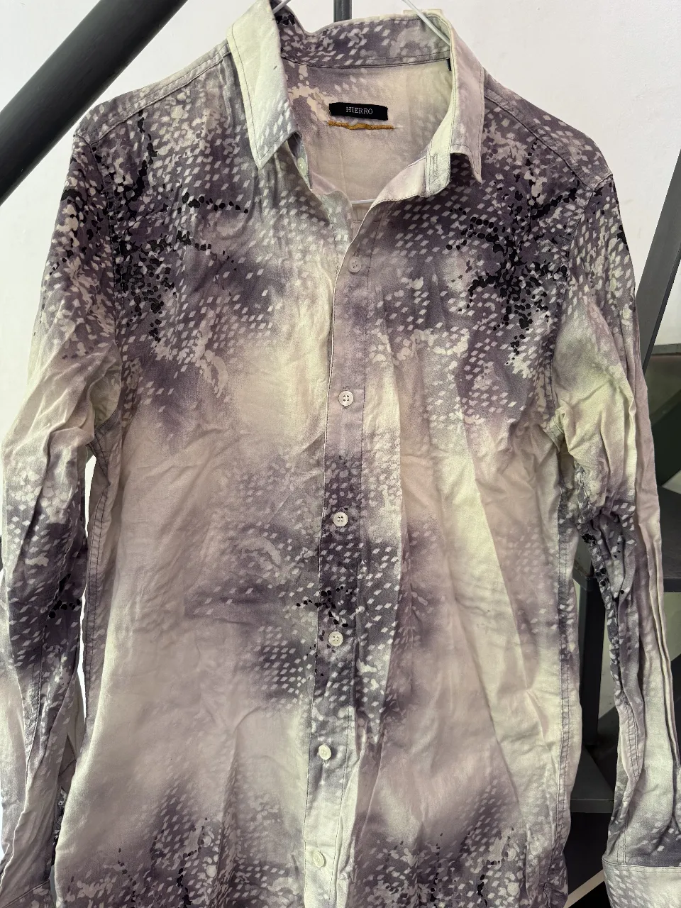 Camisa  con estampa abstracta en tonos grises y blancos. Posee cuello clásico y botones al frente. 