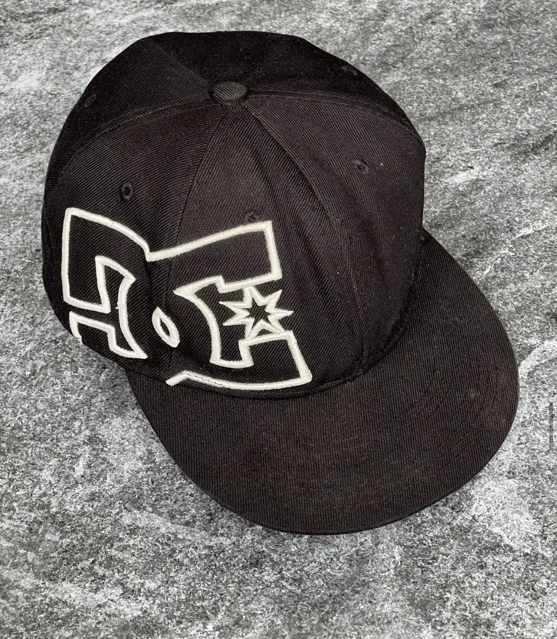 Gorra DC Shoes negra con el logo de la marca en blanco. Talle 7 1/4, 58cm. Ideal para un look urbano y casual.