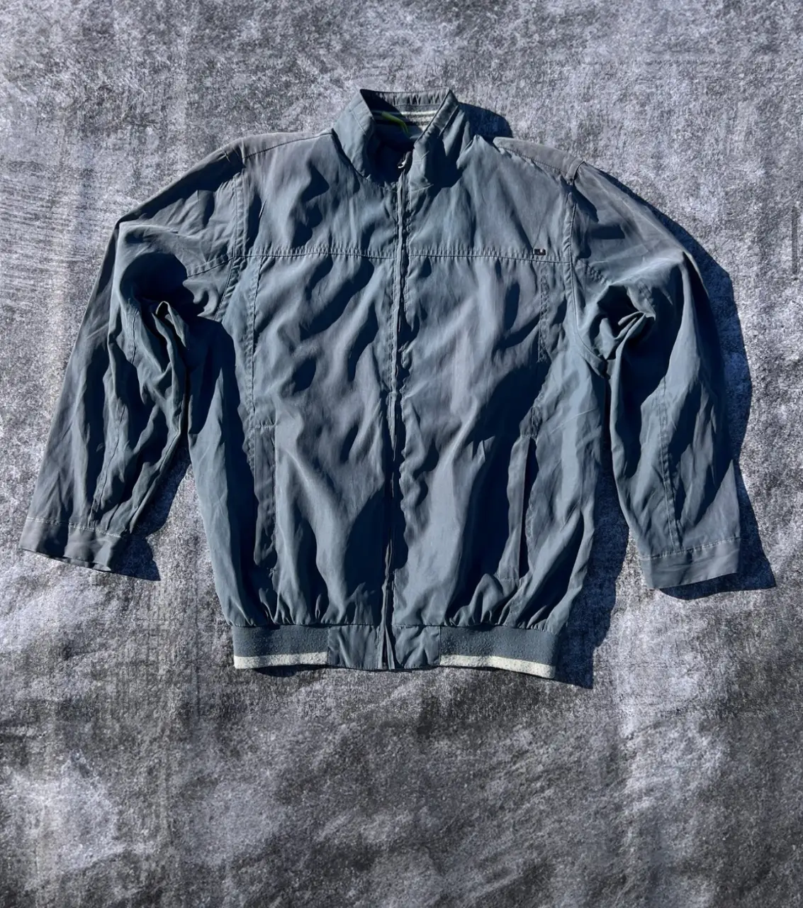 Campera bomber azul de hombre, con cierre y detalles en blanco y gris en el cuello y cintura. Marca Cacharel. MEDIDAS: Talle: M/L - Ancho: 57cm - Largo: 72cm