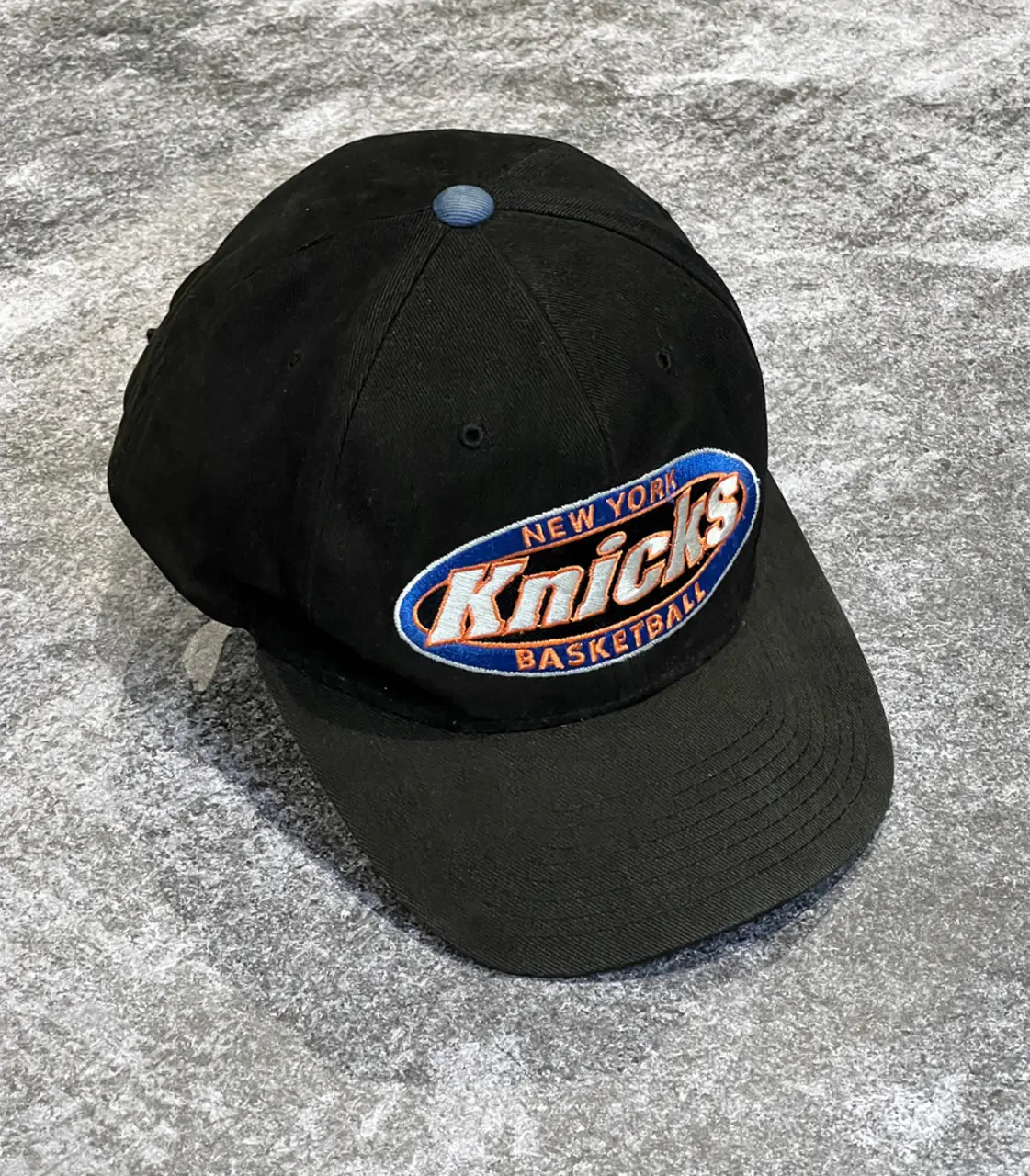 Gorra de los New York Knicks, negra con el logo bordado. Estilo vintage, ideal para fanáticos del básquet.