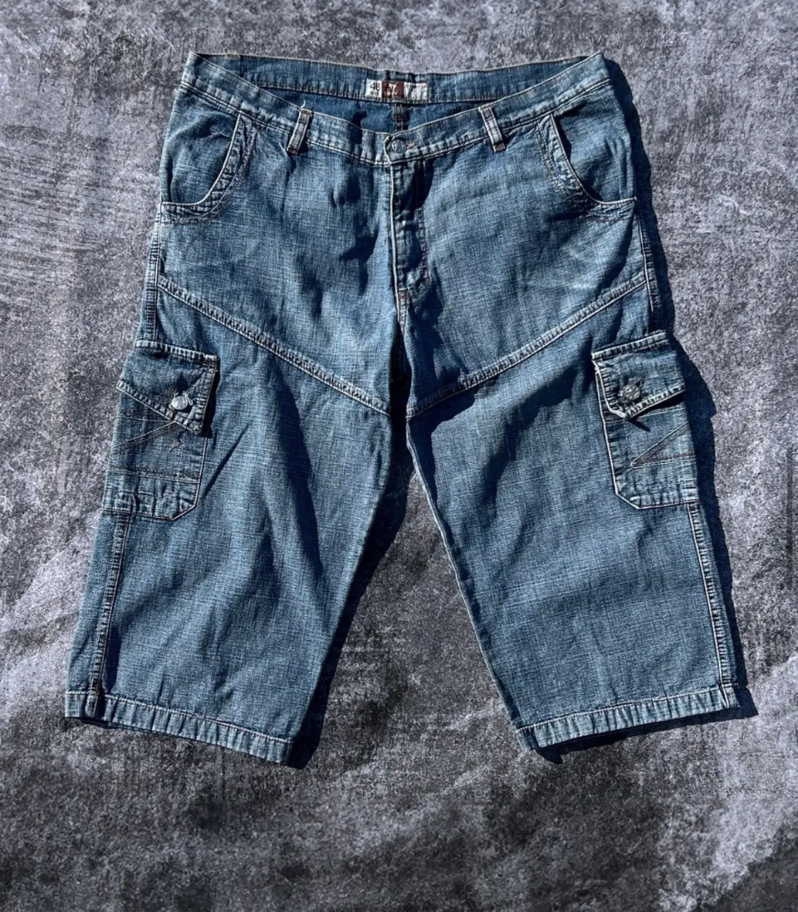Short de jean de hombre, con bolsillos cargo laterales y traseros con bordados. MEDIDAS: Talle: 48 - Largo: 77cm - Cintura: 98cm