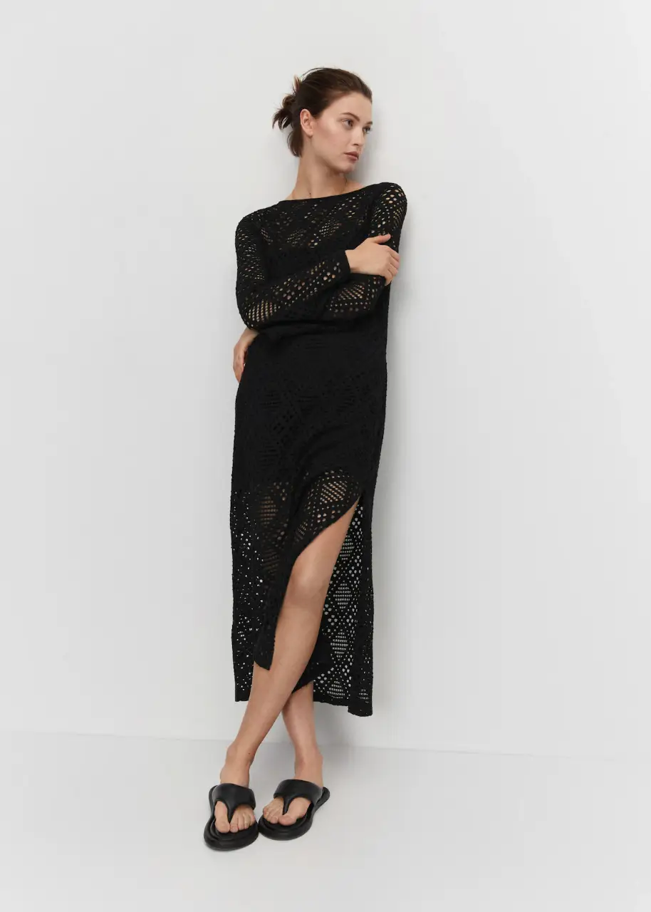 Vestido largo de red calada en color negro, con mangas largas, forro interior y abertura lateral. Sin cierre. Ideal para un look de playa o para una salida casual con un toque bohemio.