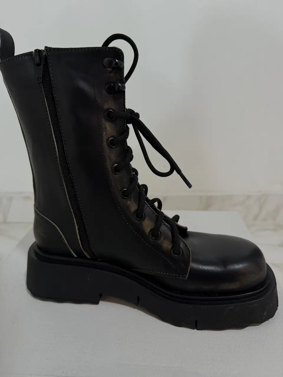 Borcegos de cuero negro con cierre lateral y cordones. Suela gruesa y diseño moderno, ideales para un look urbano y canchero.