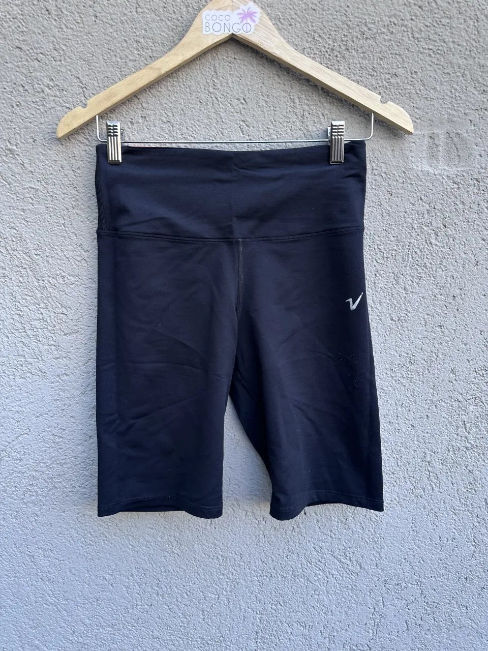 Shorts deportivos negros con logo blanco en la pierna derecha.