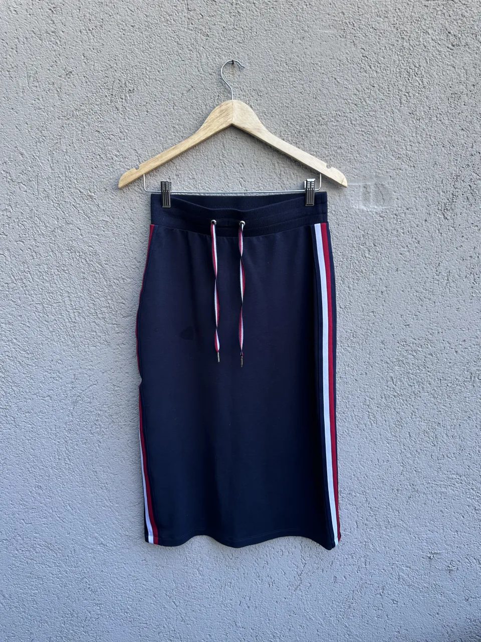 Pollera azul marino con detalles de tiras rojas y blancas a los costados. Posee cordones blancos y rojos para ajustar en la cintura.