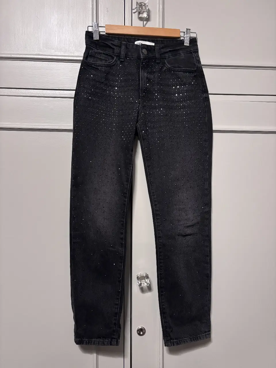 Jeans negros de tiro alto con detalles de strass. Un clásico renovado para un look de fiesta o salida.
