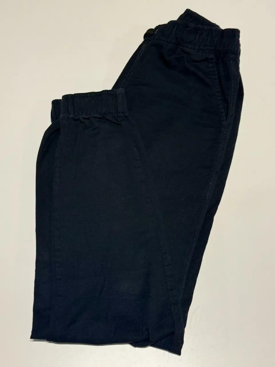 Pantalón chino negro de hombre, con cintura elastizada y puños en los tobillos. Cintura: 64 cm y 88 cm máximo con elástico estirado. . Largo: 100 cm. 