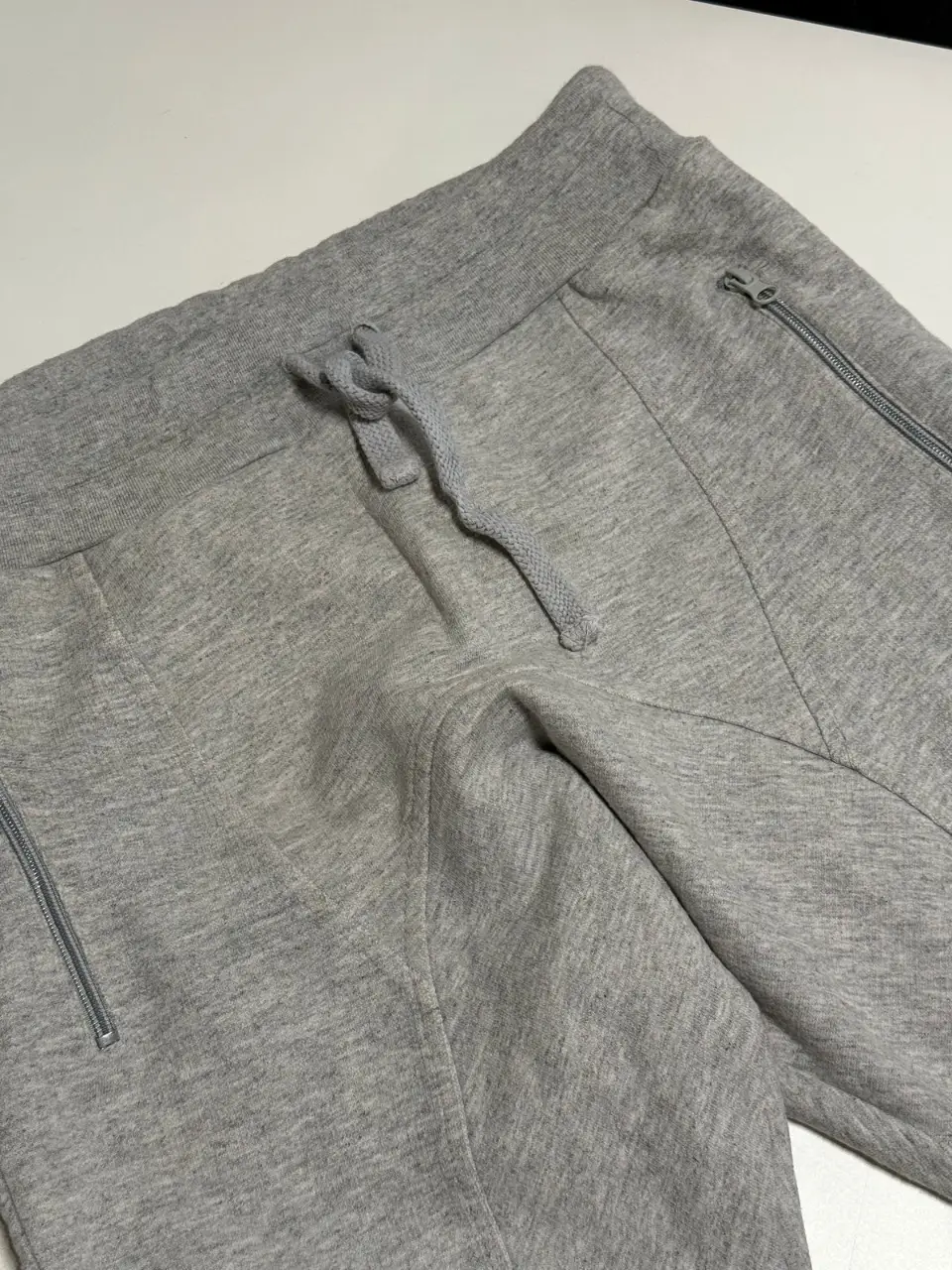 Pantalón de jogging gris con bolsillos con cierre. Ideal para un look casual y cómodo. Cintura: 74 cm sin estirar, cede a más de 100 cm. Largo: 90 cm. 