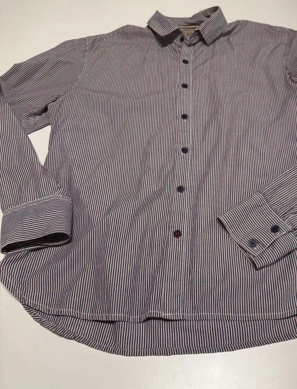 Camisa a rayas azul, blanca y roja de hombre, manga larga, corte slim. Marca Kosiuko / Herencia Argentina. Medidas: 53 cm sisa a sisa (106 cm de contorno). Largo: 97 cm.