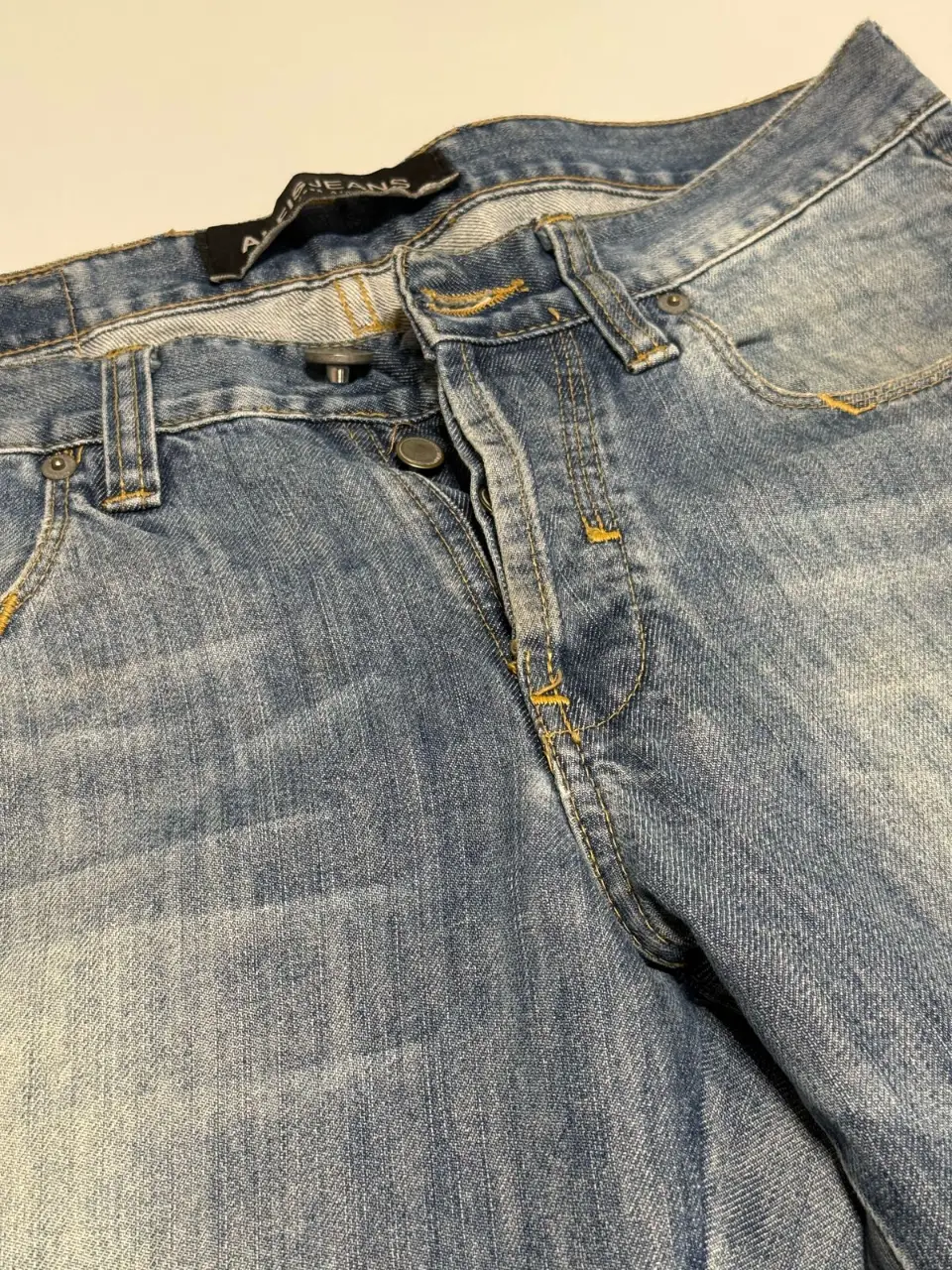 Jeans de hombre, corte recto, color azul gastado. Con detalles de costuras en amarillo y etiqueta de la marca. Talle 40. Cintura: 82 cm. Largo: 109 cm. 