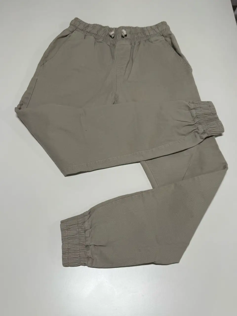 Pantalón jogger de hombre, color crudo, con cintura elastizada y puños en los tobillos. Ideal para un look casual y cómodo. Largo: 94 cm. Cintura: 66 cm cede hasta 100 cm