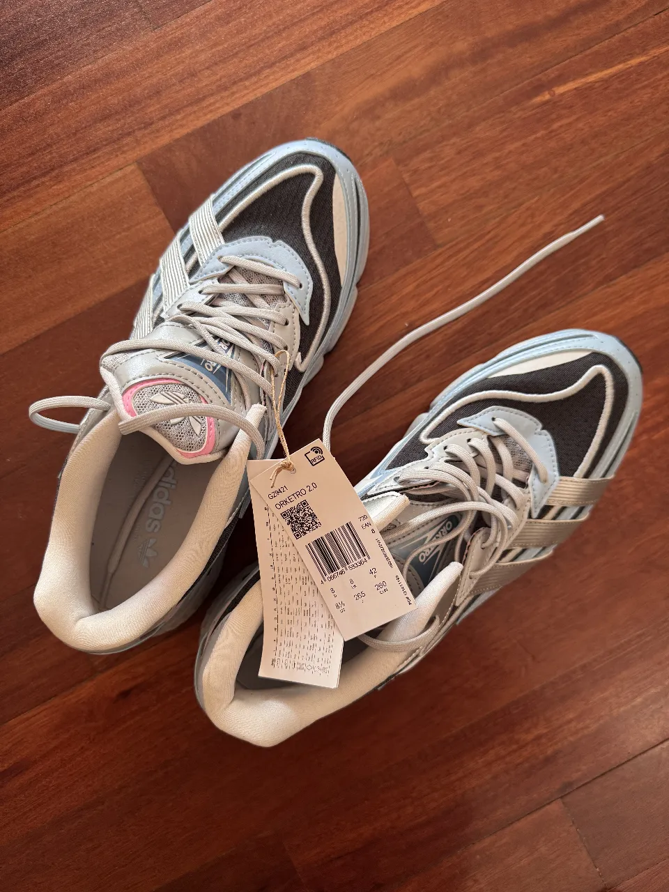 Zapatillas Adidas Orketro 2.0, diseño retro con detalles en celeste, gris y rosa. Ideales para un look deportivo y moderno.