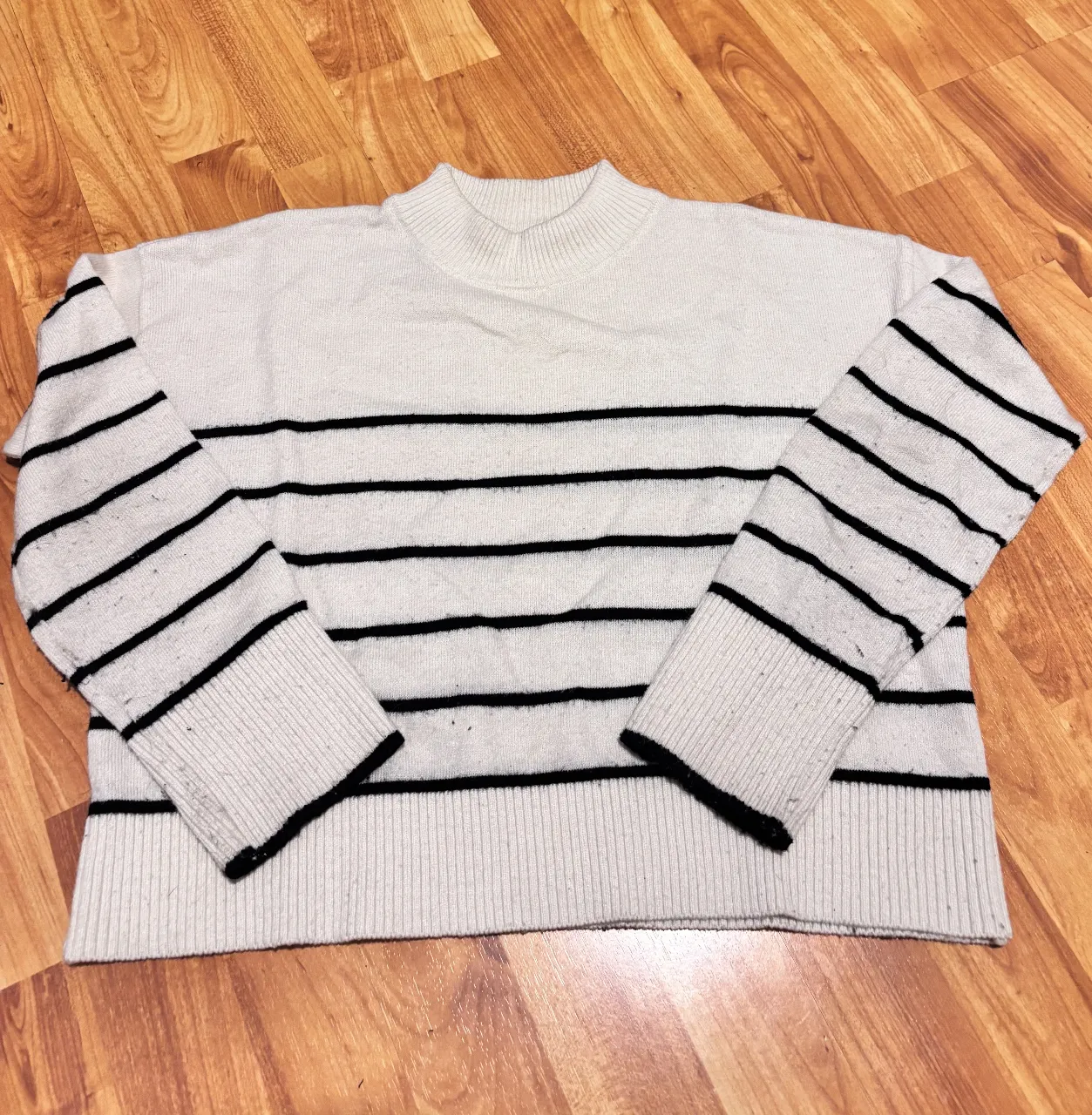 Sweater blanco con rayas negras y mangas largas. Un clásico que no puede faltar en tu guardarropa.