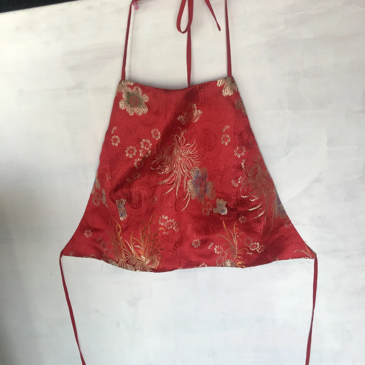  top estilo halter con un estampado floral y de símbolos chinos en tonos rojos y dorados