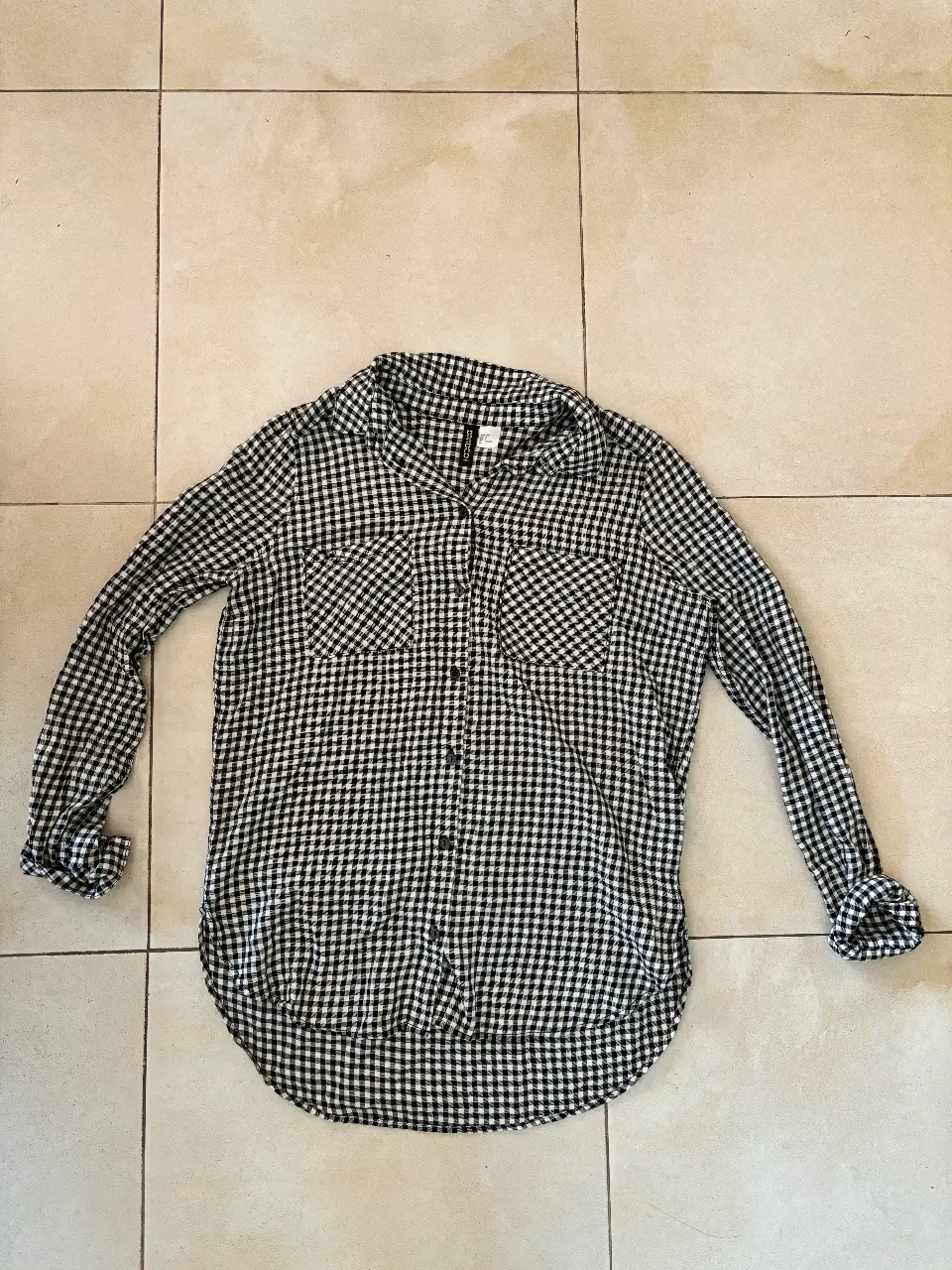 Camisa a cuadros en blanco y negro, de manga larga. Ideal para un look casual y versátil.
