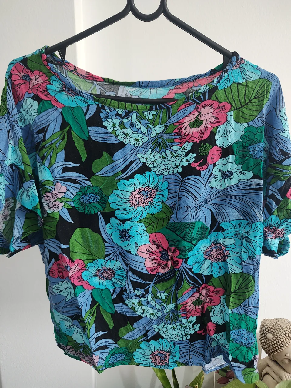 Remera manga corta con estampa floral vibrante. Ideal para un look fresco y canchero en días de sol. Combina tonos azules, verdes, rosas y fucsias sobre fondo negro. Su corte es holgado y cómodo.
